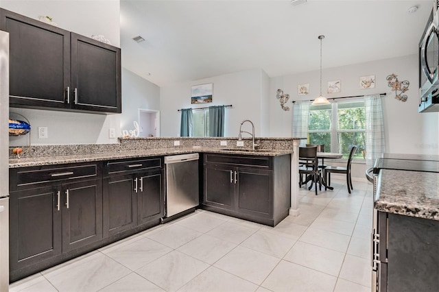 kitchen with stainless steel appliances, sink, light stone countertops, kitchen peninsula, and hanging light fixtures