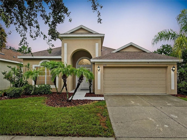 view of front of home with a yard and a garage