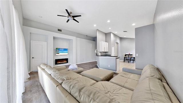 living room featuring ceiling fan and light hardwood / wood-style flooring