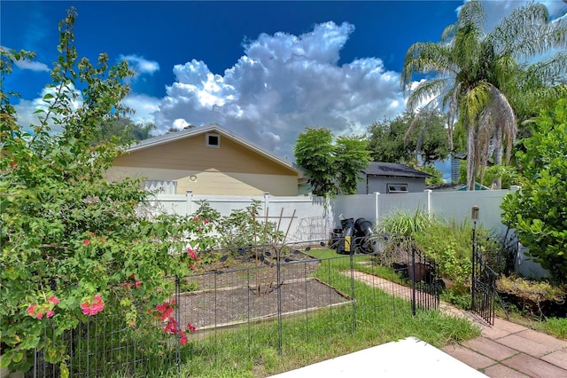 view of yard featuring fence and a garden