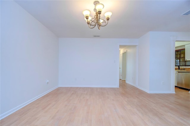 interior space with a chandelier, light wood-style flooring, visible vents, and baseboards