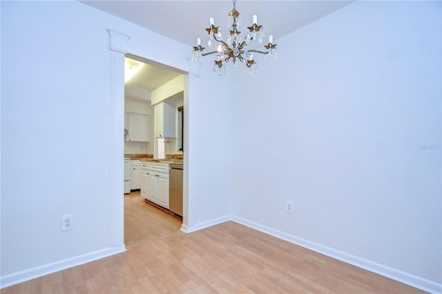 unfurnished dining area featuring a chandelier, light wood-type flooring, and baseboards