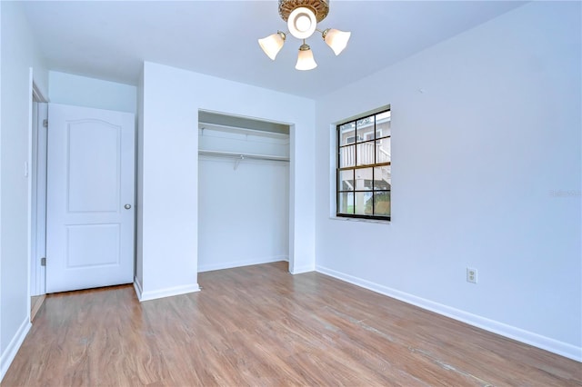 unfurnished bedroom featuring a closet, wood finished floors, and baseboards