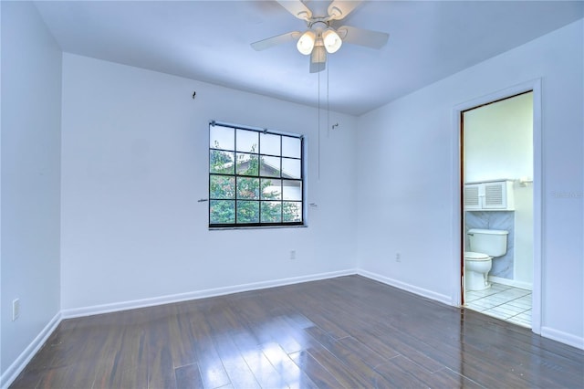 spare room with wood finished floors, a ceiling fan, and baseboards