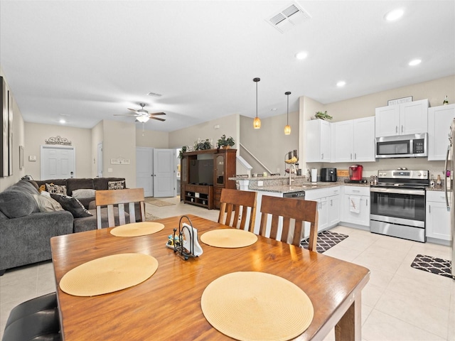 tiled dining room featuring ceiling fan and sink