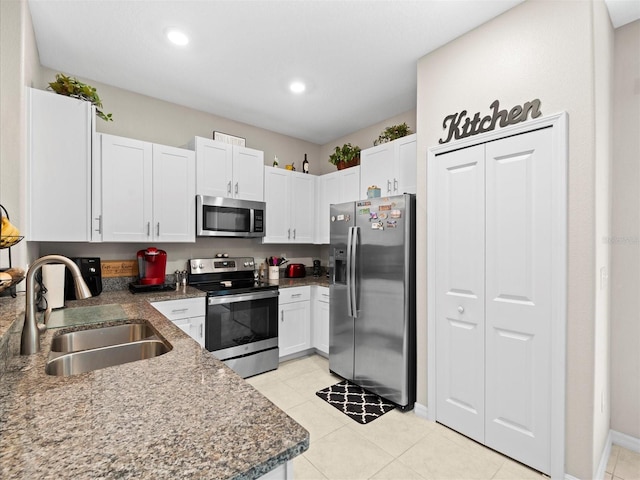 kitchen featuring light tile patterned floors, appliances with stainless steel finishes, sink, and white cabinetry