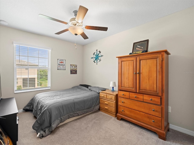 bedroom with ceiling fan and light carpet