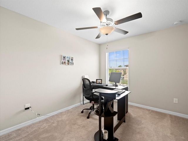 carpeted office space featuring ceiling fan