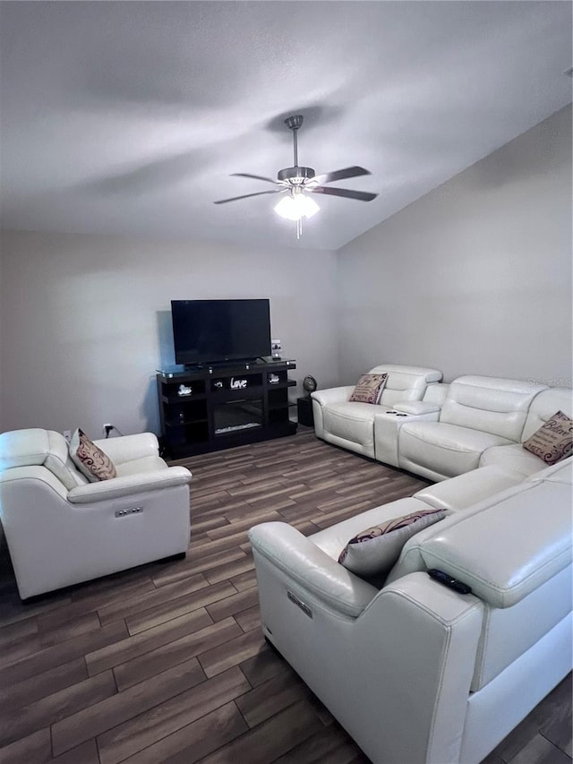 living room featuring ceiling fan and dark wood-type flooring