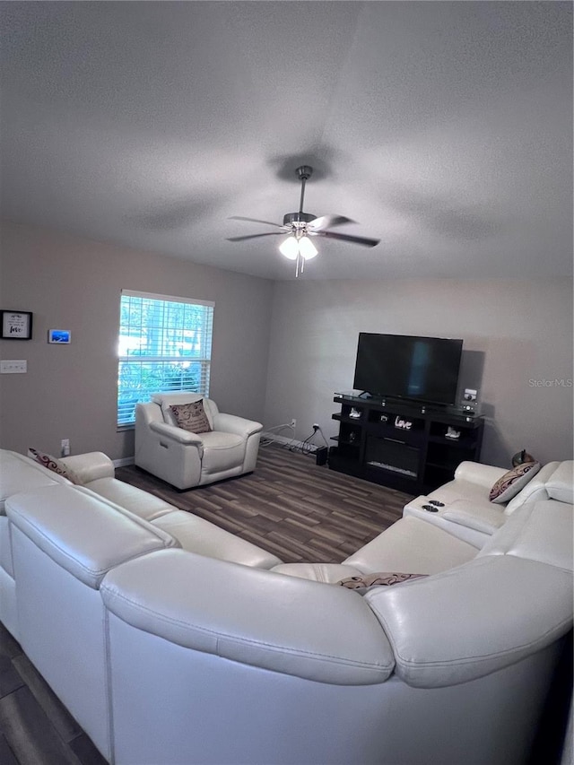 living room with a textured ceiling, ceiling fan, and hardwood / wood-style floors