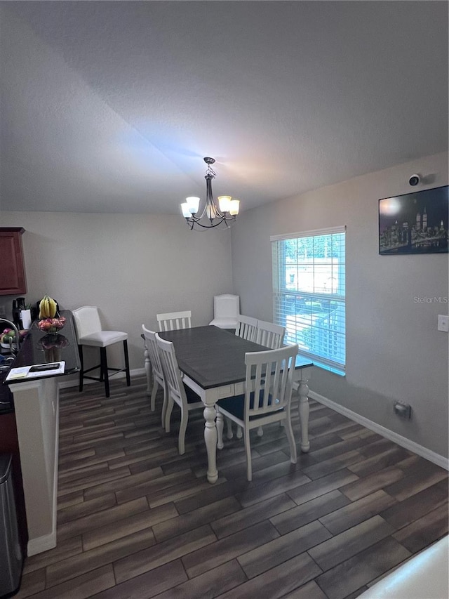 dining room with dark hardwood / wood-style floors, a notable chandelier, and lofted ceiling