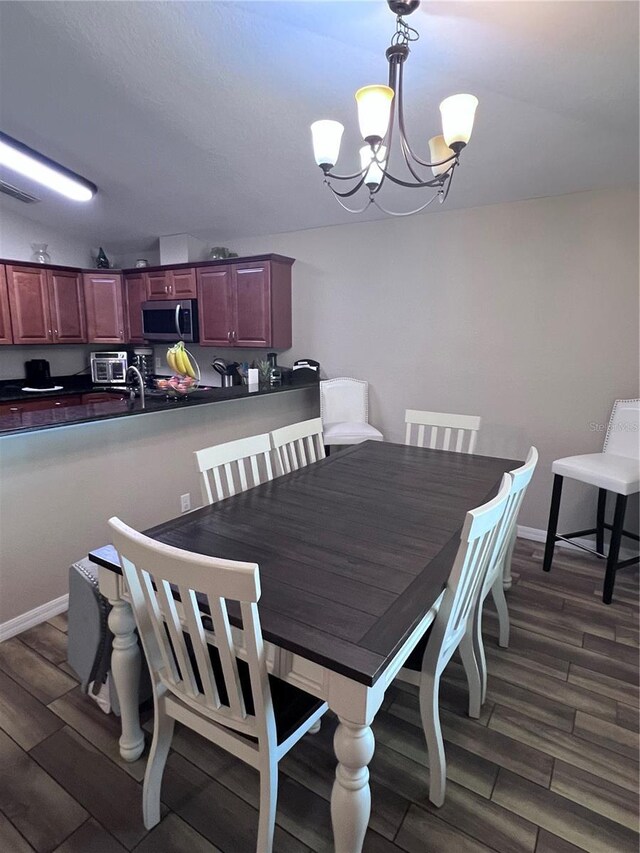 dining room featuring a notable chandelier and dark hardwood / wood-style floors