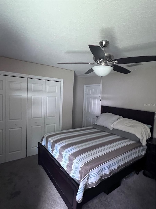 carpeted bedroom featuring ceiling fan, a closet, and a textured ceiling