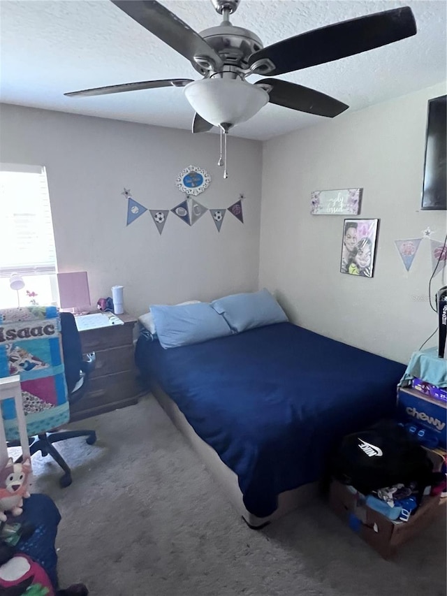 bedroom featuring ceiling fan, a textured ceiling, and carpet floors