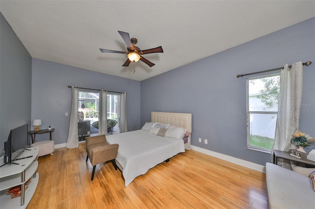 bedroom with ceiling fan, access to outside, light wood-type flooring, and baseboards