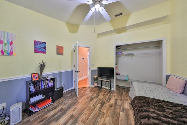 bedroom featuring a closet, wood finished floors, visible vents, and a ceiling fan