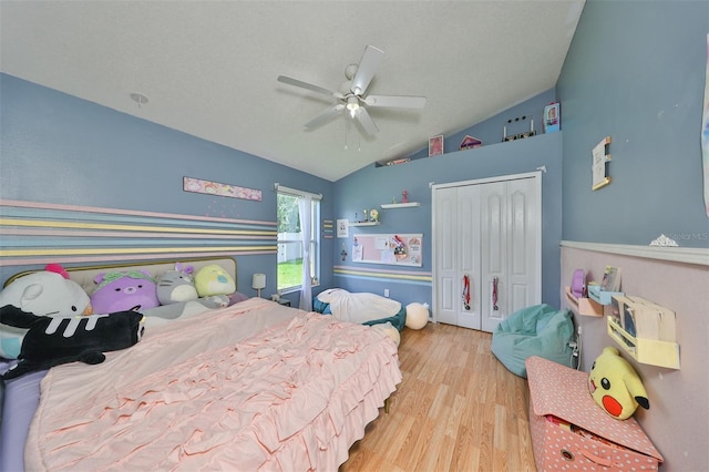 bedroom featuring a ceiling fan, vaulted ceiling, a closet, and wood finished floors