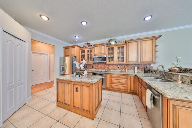 kitchen featuring light stone countertops, stainless steel appliances, ornamental molding, sink, and decorative backsplash