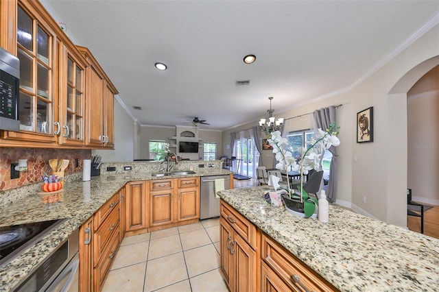 kitchen featuring stainless steel appliances, arched walkways, a sink, and ornamental molding