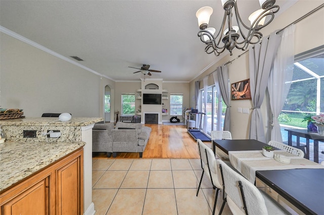 dining room featuring light wood-type flooring, ceiling fan with notable chandelier, and ornamental molding