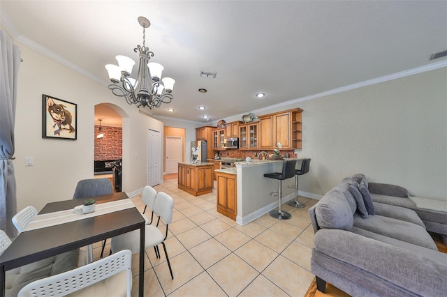 kitchen featuring arched walkways, brown cabinets, stainless steel appliances, glass insert cabinets, and open floor plan