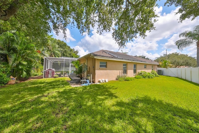 rear view of house featuring a yard and a lanai