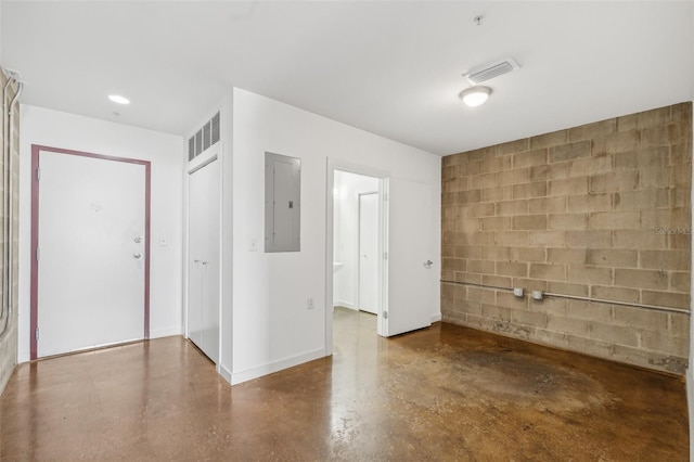 unfurnished room featuring concrete flooring and electric panel