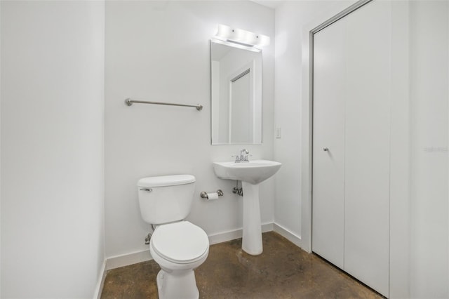 bathroom featuring concrete floors and toilet