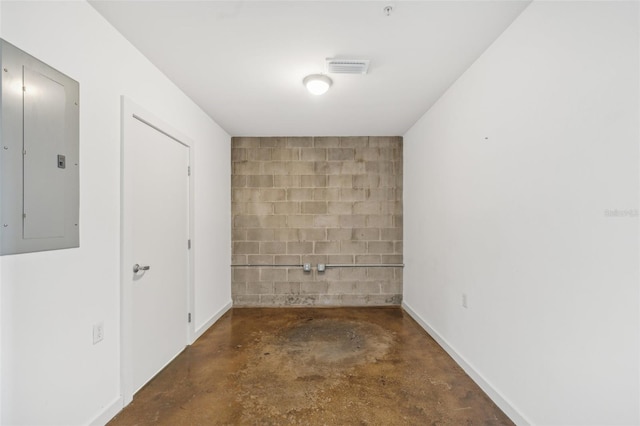 empty room featuring concrete flooring and electric panel