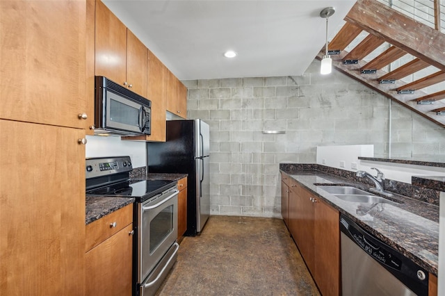 kitchen with sink, stainless steel appliances, dark stone countertops, and decorative light fixtures