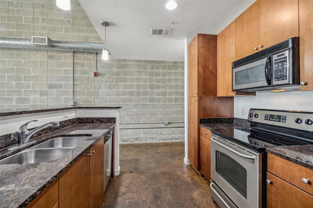 kitchen with sink, dark stone countertops, hanging light fixtures, and stainless steel appliances