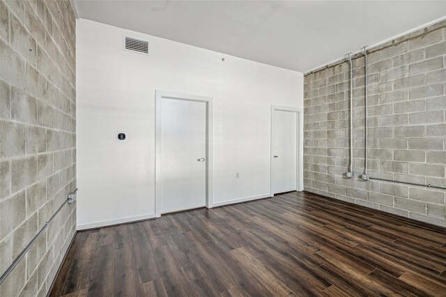 unfurnished bedroom featuring visible vents and dark wood finished floors