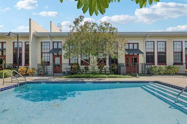 community pool featuring a patio area and fence