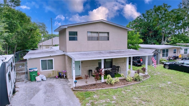 view of front of property featuring covered porch and a front lawn