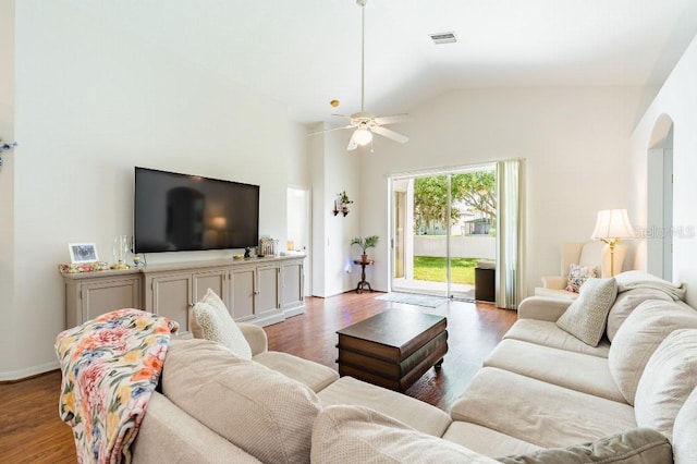 living room with baseboards, visible vents, arched walkways, lofted ceiling, and wood finished floors