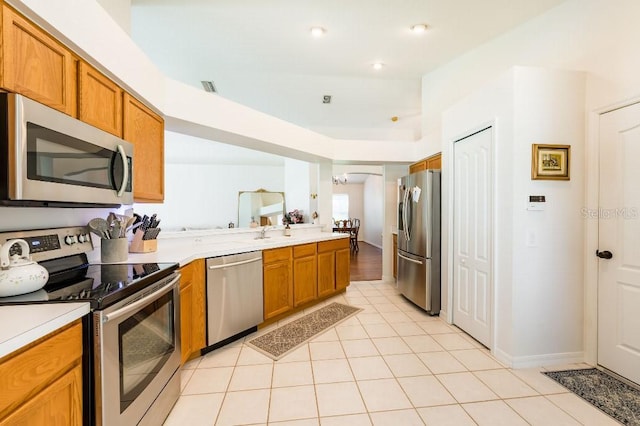 kitchen with brown cabinets, light tile patterned floors, light countertops, visible vents, and appliances with stainless steel finishes