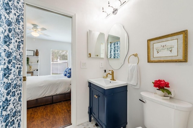 full bathroom with toilet, ceiling fan, vanity, and ensuite bathroom