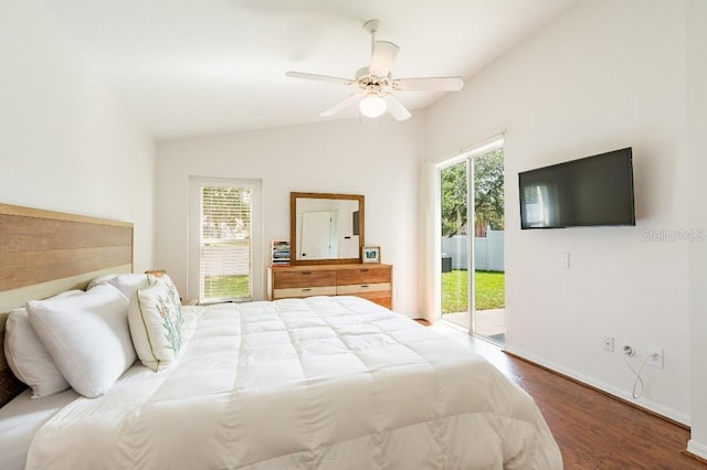 bedroom featuring lofted ceiling, multiple windows, wood finished floors, and access to exterior