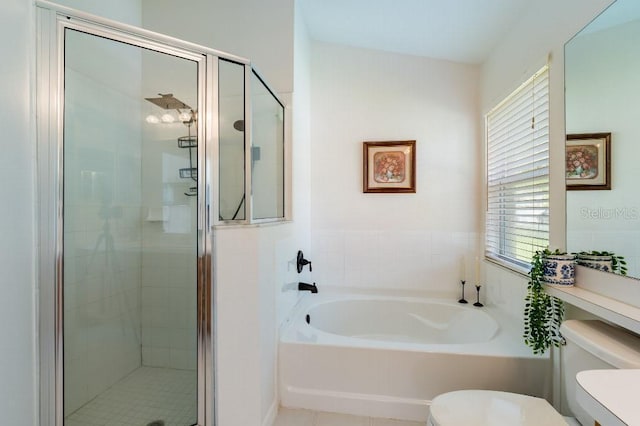 bathroom with toilet, a stall shower, and a garden tub