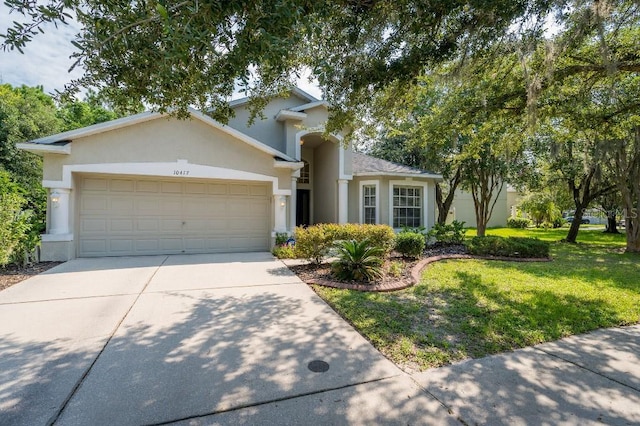 single story home featuring a garage, driveway, a front lawn, and stucco siding