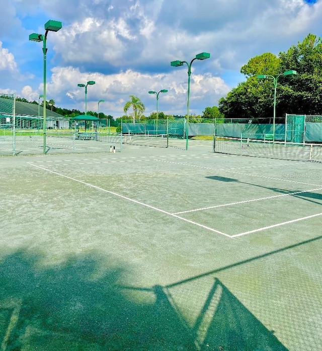 view of tennis court featuring fence