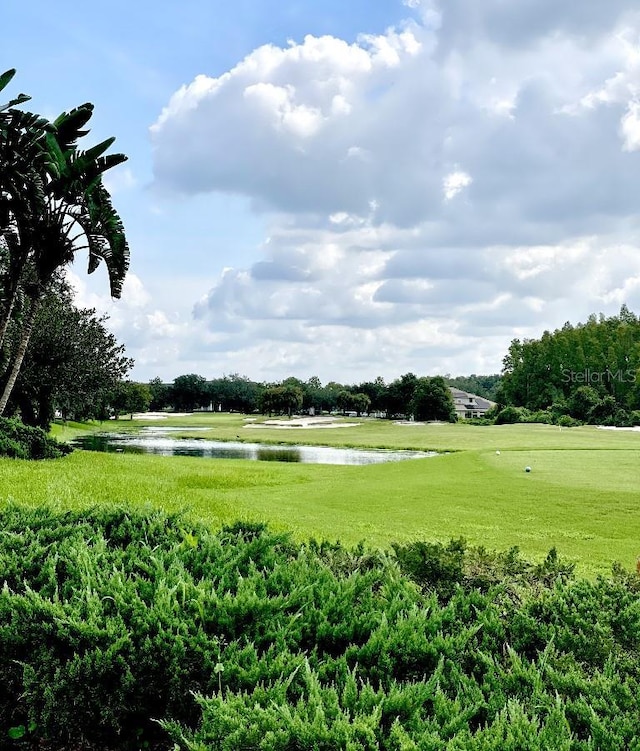 surrounding community with a lawn and a water view