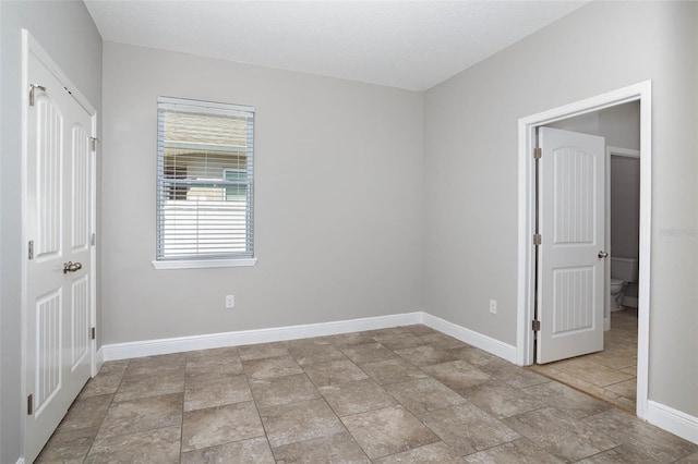 unfurnished room featuring baseboards