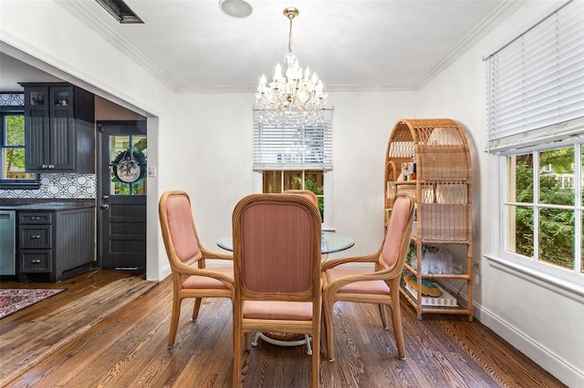 dining area with dark hardwood / wood-style flooring, a chandelier, and ornamental molding