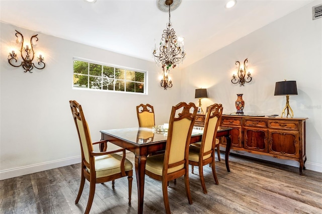 dining area with wood-type flooring and a chandelier