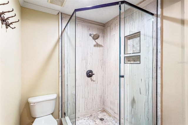 bathroom featuring a textured ceiling, toilet, and walk in shower