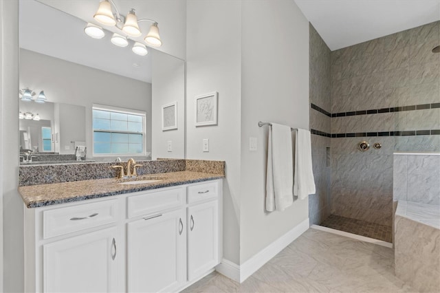 bathroom with tiled shower and vanity