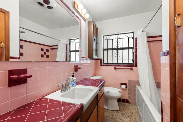 full bathroom featuring a wealth of natural light, shower / bath combination with curtain, vanity, and toilet