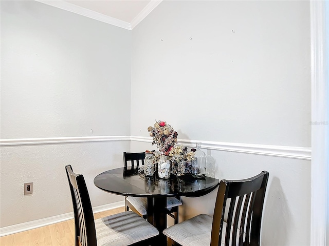 dining area featuring light hardwood / wood-style flooring and crown molding