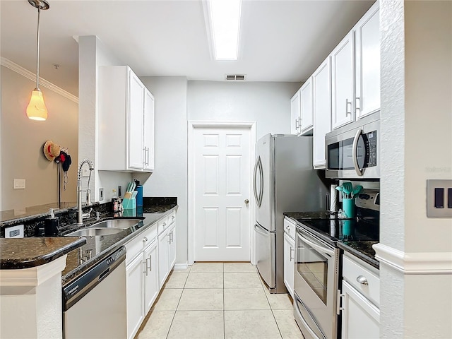 kitchen featuring ornamental molding, white cabinetry, decorative light fixtures, appliances with stainless steel finishes, and light tile patterned floors